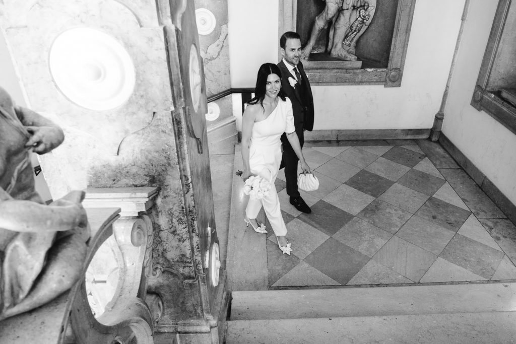 Das Brautpaar kommt die Stufen im Schloss Mirabell hoch.