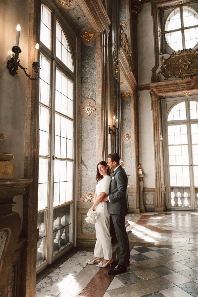 Das Brautpaar steht am Fenster vom Trauungssaal und genießt die ersten Minuten als offizielles Ehepaar.